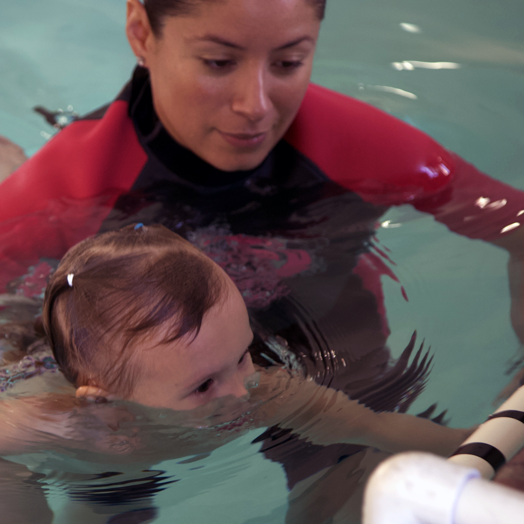 Sandra Koury teaching a baby to float during a swim lesson